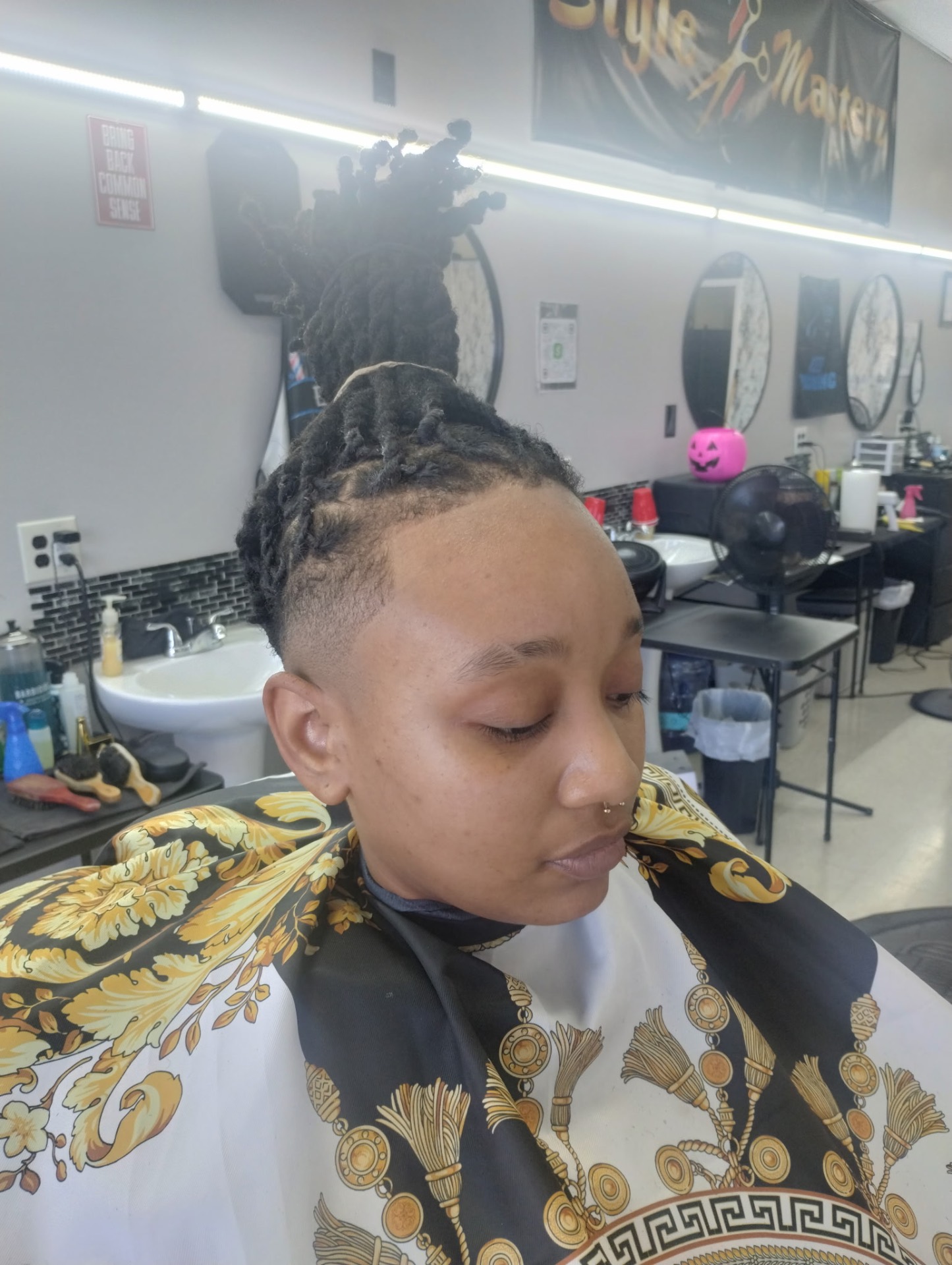 Sculpted loc updo with bald fade by Style Masterz