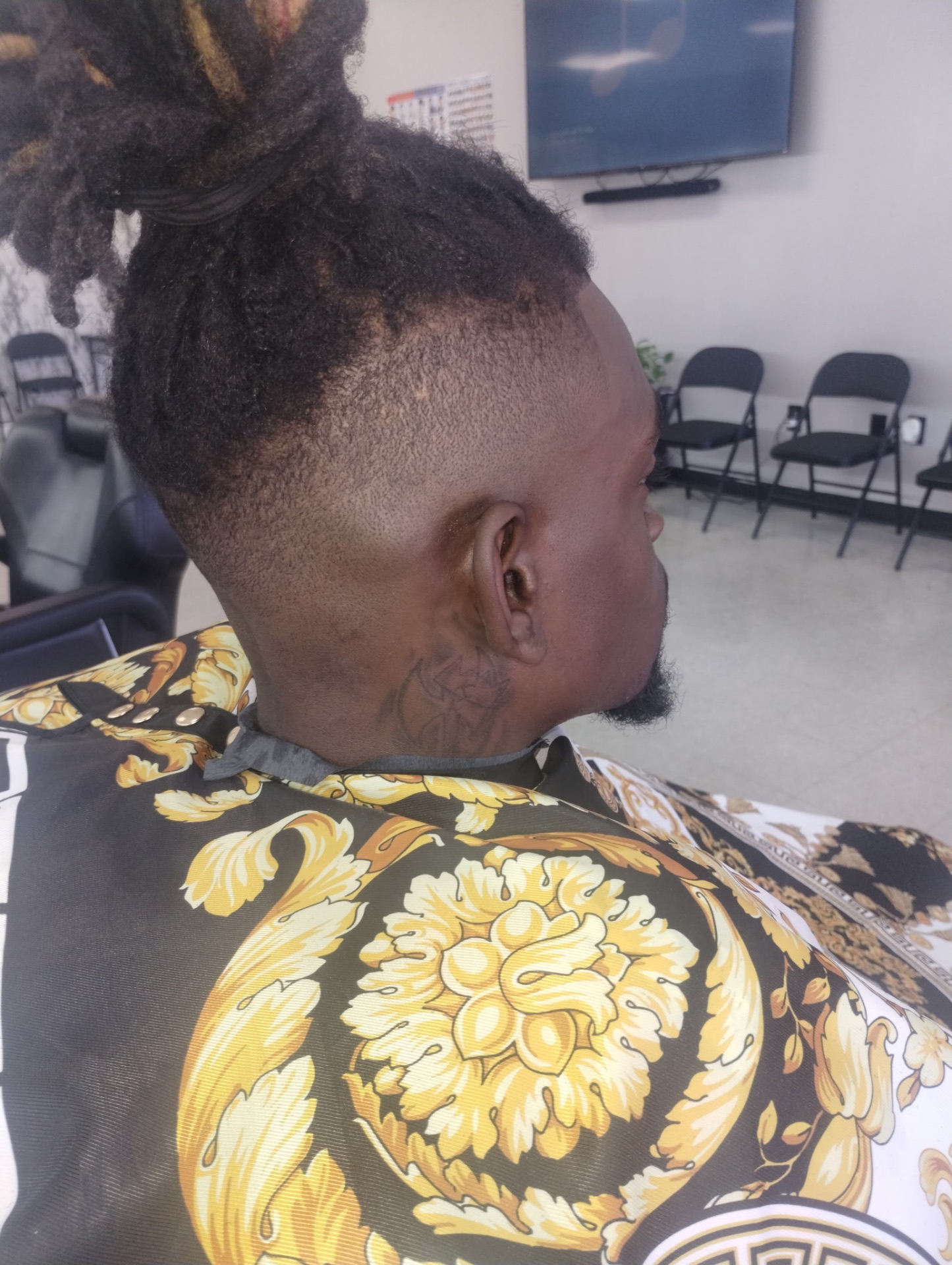 Loc man bun with high bald fade — back view