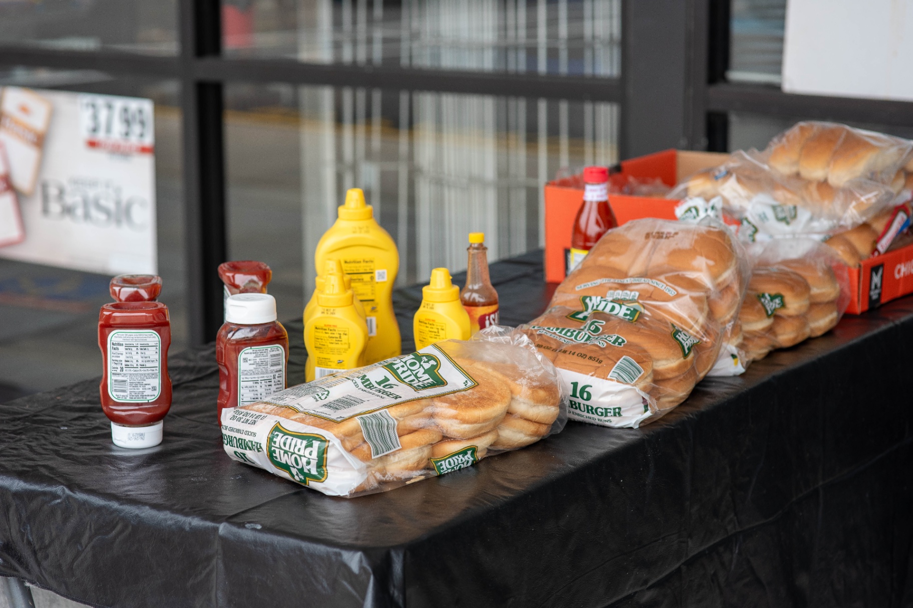 Buns, condiments, and food laid out on the table