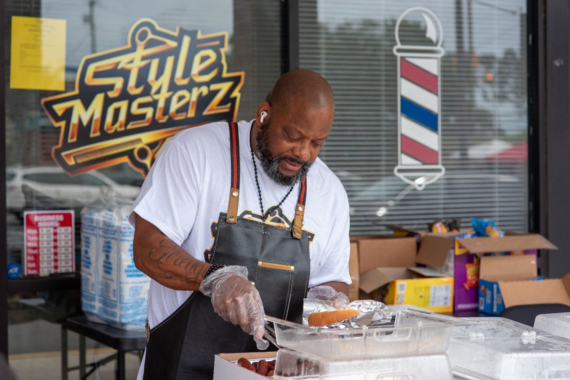 Owner serving hot dogs off the grill