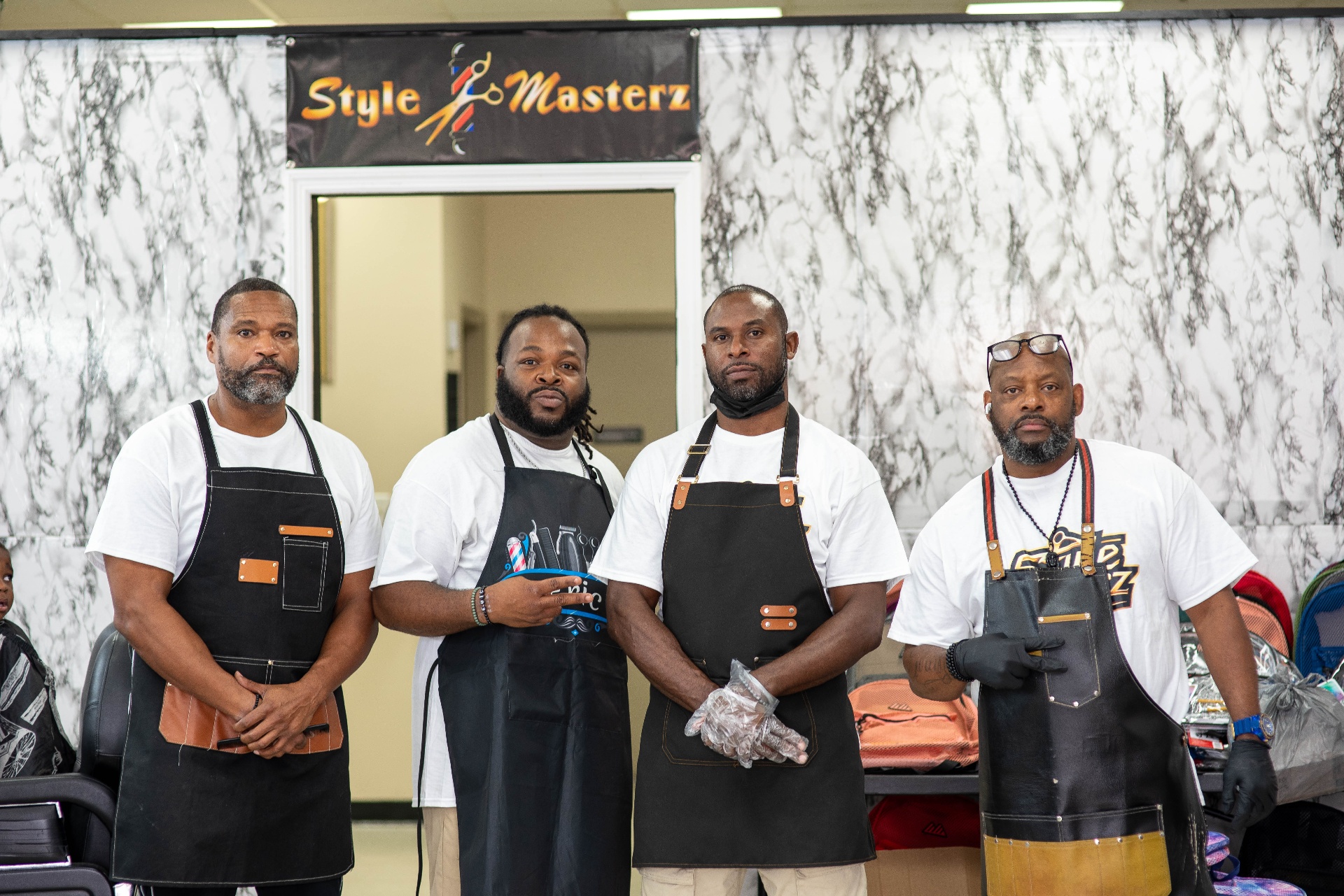 The Style Masterz barber team in aprons at the Fayetteville studio