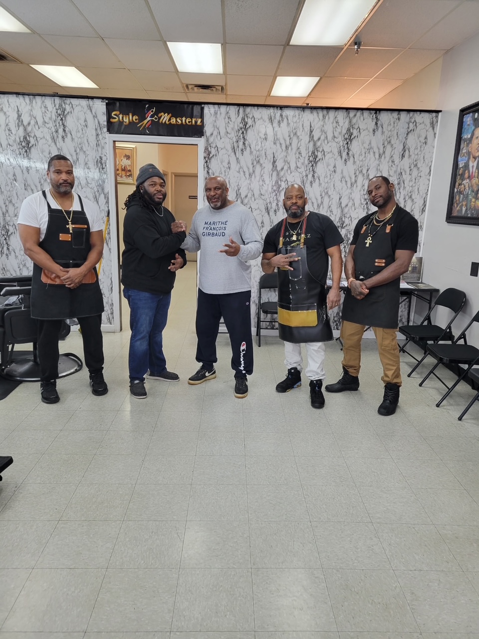The full Style Masterz barber crew posing under the shop sign